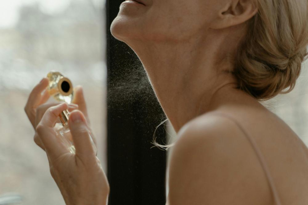 mujer aplicando perfume en el cuello