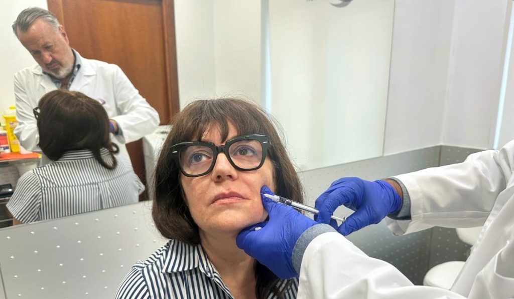 Doctor realizando un tratamiento de rejuvenecimiento facial con neuromoduladores y ácido hialurónico durante la consulta.